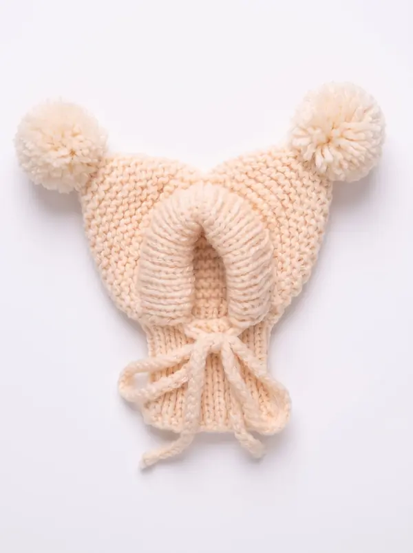 Beige knitted dog hood with two pom-poms