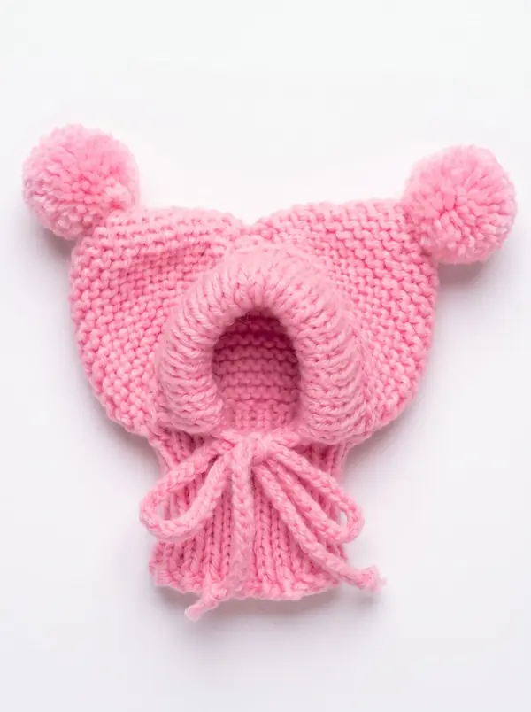 Pink knitted dog hood with two pom-poms