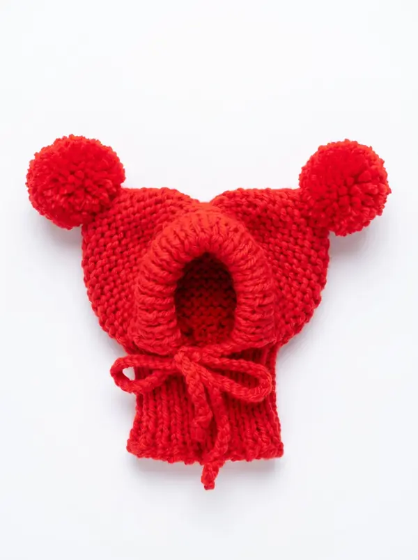 Red knitted dog hood with two pom-poms