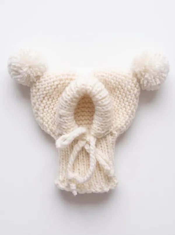 White knitted dog hood with two pom-poms